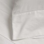 Close-up of hemstitch detailing on white cotton sateen sheet corner