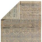 Rug corner flipped to show front and back side with detailed traditional pattern and subdued colors