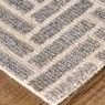 Close-up corner view displaying thick hand-tufted texture and edge binding on wooden floor
