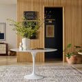 Living room scene with rug under round white marble table against modern wood wall paneling