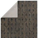 Backside of rug folded over to reveal light grey woven backing