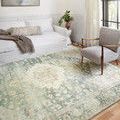 Rosette rug in a bright living room setting with white sofa, armchair, and natural light showing overall ambiance