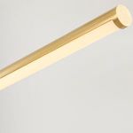 Detail of one cylindrical aged brass light bar with frosted diffuser covering the LED light source