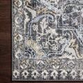 Top-down close-up of rug corner showing intricate pattern details and charcoal border on dark hardwood floor