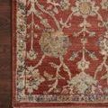 Close-up corner of Giada red rug on dark wood floor highlighting intricate floral details and texture