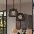 Side view of two Osbert Black Pendants showing chain suspension and room background with art panels