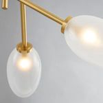 Close-up of two frosted oval glass shades with warm light and aged brass mounts