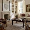 Living room view with rug near fireplace and built-in shelves, showing more of the room’s right side including windows and...
