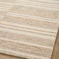 Detailed corner of Chris Ivory Clay Rug flat on wood floor highlighting soft tonal stripes