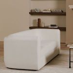 Alora sofa styled in cozy living room setting with shelving and beige walls.