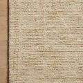 Zoomed top view of Penny Gold rug edge showing detailed wool loops and natural fiber variation on wooden floor