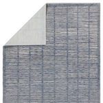 Rug corner folded to reveal the light gray non-slip backing underside