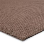 Close-up showing detailed chunky weave texture and thick yarn edge binding of the solid brown rug.