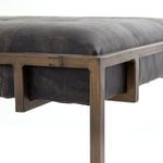Profile view capturing tufted leather edge and horizontal cage panel detail
