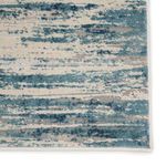 Detailed view of Heaston Rug edge with finished binding and textured abstract blue and gray stripes