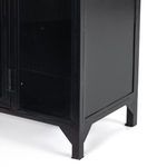 Detailed view of tapered feet supporting black metal cabinet, showing matte finish