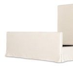 Side angled view showing slipcover hem draping slightly away from floor and smooth fabric finish