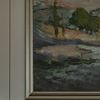 Close-up of painting corner showing silver frame and brushstroke texture on paneled wall