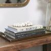 Kenya Cow Bone Drum Beads styled on stacked home decor books on a wooden table