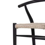 Close-up of curved teak armrest and seat weaving contrast