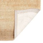 Top corner flipped to reveal woven rug backing and secure edge binding