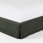Close-up on bed frame corner highlighting precise slipcover fit and fabric weave