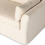 Close-up of flared rolled arm and seam detail on beige slipcover fabric