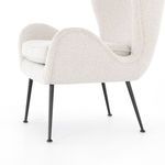 Side angled view highlighting the chair's curved armrest and black metal legs