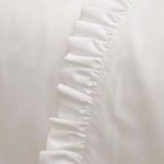 Close-up of ruffled edge detail on white cotton percale fabric showing texture and stitching