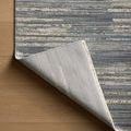 Rug corner lifted to expose tightly woven backing and underside in lighter color
