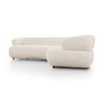 Side profile emphasizing flowing, curved shape and sculpted armrest of sectional sofa