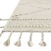 Close-up of rug corner showing braided fringe and textured wool and cotton fibers