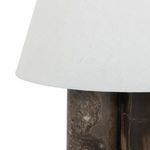 Side view focusing on white lamp shade edge and top of marble pillar base