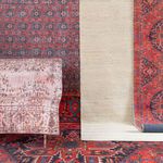 Rug displayed upright against colorful layered traditional rugs with intricate patterns