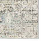 Detailed close-up of rug corner showing dense pile and subtle floral design in muted tones