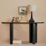Console table styled in living room setting with lamp, books, decorative objects, and wall art