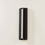 Dune sconce side view on an off-white wall, emphasizing the narrow gap between metal flanges and light diffusion