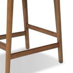 Close-up of sturdy wooden legs and footrest bars in warm wood tone