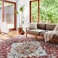 Samra Brick Grey Rug styled in bright room with modern sofa, white chair, wooden floor, and green plants