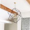 Close-up side angle of geometric black and gold ceiling light fixture with wooden ceiling beams