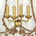 Close-up of gold candle-style lights and central metal ball with rope-wrapped arms and dangling rope balls