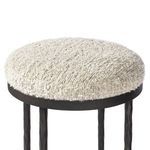 Close-up top portion of round cushioned boucle-like seat on Corinne Stool