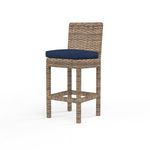 Havana Counter Stool in aged tobacco wicker with navy blue cushion, tall wicker legs, and supportive backrest