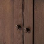 Close-up of round wooden knobs on sideboard cabinet doors