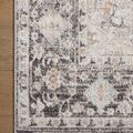 Corner of rug on wooden floor revealing detailed border and soft texture