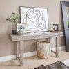Single framed Black Circles IV painting leaning on ornate console table with decorative objects and plant