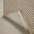 Corner of rug flipped to show tightly woven underside backing