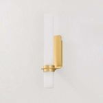 Groveland Station Wall Sconce with matte cloud glass tube and brushed brass metal backplate mounting vertically on wall