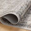 Curled edge close-up revealing the underside weave and thickness of the rug
