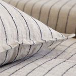 Close-up showing piped edge detail of Blake duvet cover and matching pillow sham in striped linen fabric